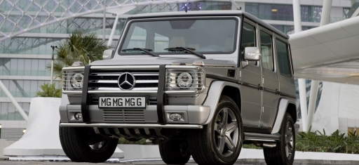Silver SUV parked outside a modern building, the kind of vehicle used for secure ground transport