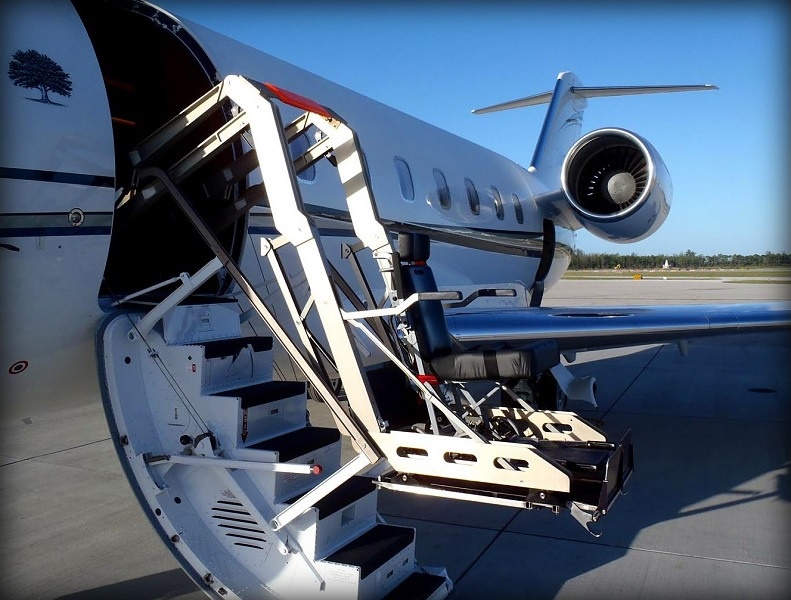 Wheelchair lift raising a passenger to the door of a private jet for a Kentucky charter flight